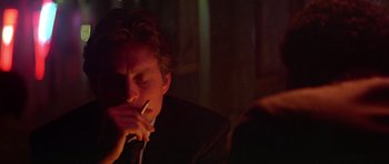 Movie still from “The Star Chamber” (1983), directed by Peter Hyams – A man smoking a cigarette in a dark room; Close Up shot, Over the shoulder angle