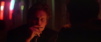 Movie still from “The Star Chamber” (1983), directed by Peter Hyams – A man smoking a cigarette in a dark room; Close Up shot, Over the shoulder angle