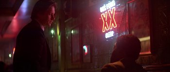 Movie still from “The Star Chamber” (1983), directed by Peter Hyams – A man and a woman are talking in front of a neon sign; Medium shot, Over the shoulder angle