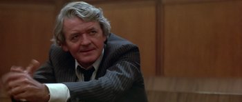 Movie still from “The Star Chamber” (1983), directed by Peter Hyams – An older man wearing a suit and tie sitting down; Close Up shot, Low angle