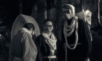 Movie still from “The State of Things” (1982), directed by Wim Wenders – A group of people standing next to each other; Medium shot, Low angle