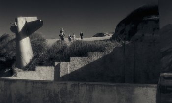 Movie still from “The State of Things” (1982), directed by Wim Wenders – A black and white photo of people walking up a hill; Extreme Wide shot, Low angle
