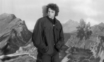 Movie still from “The State of Things” (1982), directed by Wim Wenders – Black and white photograph of a man standing in front of mountains; Medium shot, Low angle