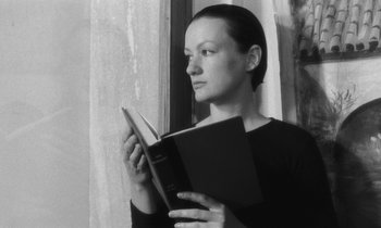 Movie still from “The State of Things” (1982), directed by Wim Wenders – A woman is reading a book by a window; Close Up shot, Low angle