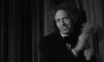 Movie still from “The State of Things” (1982), directed by Wim Wenders – Black and white photograph of a man in a suit and bow tie; Close Up shot, Over the shoulder angle