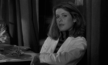Movie still from “The State of Things” (1982), directed by Wim Wenders – Black and white photograph of a woman sitting at a table; Close Up shot, Over the shoulder angle