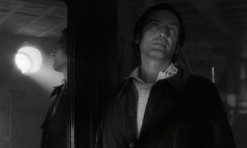 Movie still from “The State of Things” (1982), directed by Wim Wenders – A black and white photo of a man looking at himself in a mirror; Close Up shot, Low angle