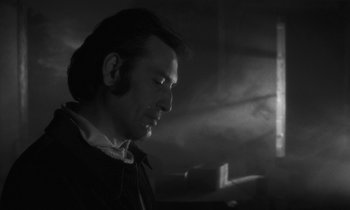 Movie still from “The State of Things” (1982), directed by Wim Wenders – A black and white photo of a man looking down; Close Up shot, Low angle