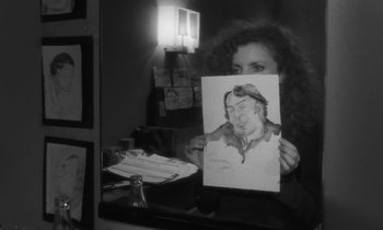 Movie still from “The State of Things” (1982), directed by Wim Wenders – A woman holding up a picture of a man; Close Up shot, Over the shoulder angle