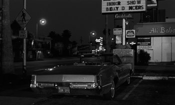 Movie still from “The State of Things” (1982), directed by Wim Wenders – A car parked on the side of the road at night; Wide shot, Low angle