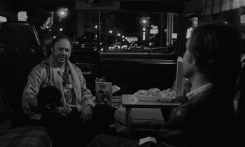 Movie still from “The State of Things” (1982), directed by Wim Wenders – A man and a woman sitting in the back of a car; Medium shot, Over the shoulder angle