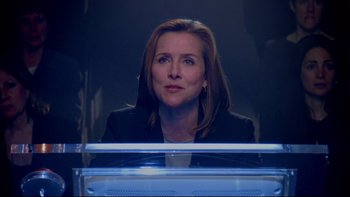 Movie still from “The Stepford Wives” (2004), directed by Frank Oz – A woman sitting in front of a glass case; Close Up shot, Low angle