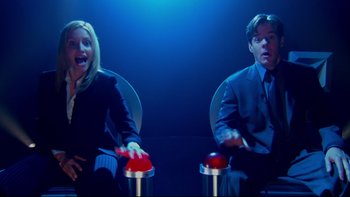 Movie still from “The Stepford Wives” (2004), directed by Frank Oz – A man and a woman sitting in chairs in front of each other; Medium shot, High angle