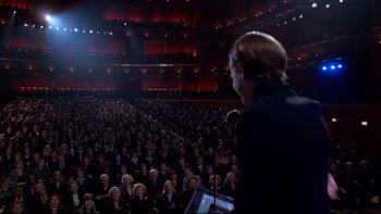 Movie still from “The Stepford Wives” (2004), directed by Frank Oz – A crowd of people sitting in a large auditorium; Extreme Wide shot, High angle
