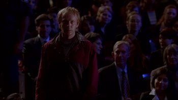 Movie still from “The Stepford Wives” (2004), directed by Frank Oz – A man standing in front of a crowd of people; Medium shot, Over the shoulder angle