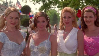 Movie still from “The Stepford Wives” (2004), directed by Frank Oz – Two beautiful women standing next to each other in a park; Medium shot, Low angle