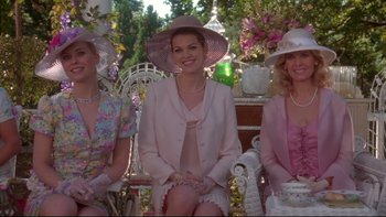 Movie still from “The Stepford Wives” (2004), directed by Frank Oz – A group of women sitting next to each other on a park bench; Medium shot, Low angle