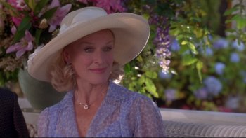 Movie still from “The Stepford Wives” (2004), directed by Frank Oz – A woman wearing a white hat sitting on a bench; Close Up shot, Over the shoulder angle