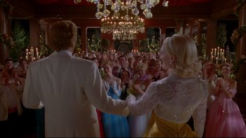 Movie still from “The Stepford Wives” (2004), directed by Frank Oz – A group of people standing in front of each other in a room; Wide shot, Over the shoulder angle