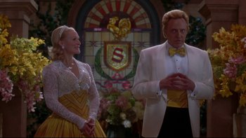 Movie still from “The Stepford Wives” (2004), directed by Frank Oz – A man and a woman standing next to each other in front of a stained glass window; Medium shot, Low angle