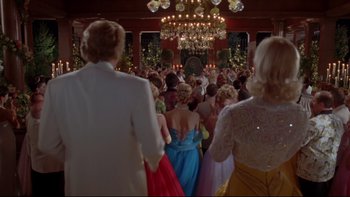 Movie still from “The Stepford Wives” (2004), directed by Frank Oz – A group of people standing in front of chandeliers; Wide shot, Low angle