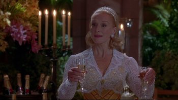 Movie still from “The Stepford Wives” (2004), directed by Frank Oz – A woman holding a glass of wine in a room with lit candles; Close Up shot, Over the shoulder angle