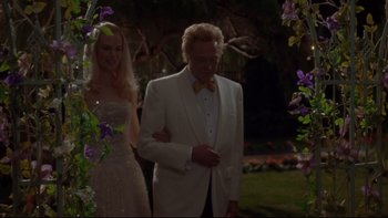 Movie still from “The Stepford Wives” (2004), directed by Frank Oz – A man in a white suit and a woman in a white dress; Medium shot, Low angle
