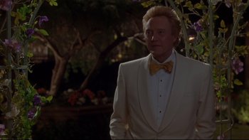 Movie still from “The Stepford Wives” (2004), directed by Frank Oz – A man in a white suit and yellow bow tie; Medium shot, Low angle