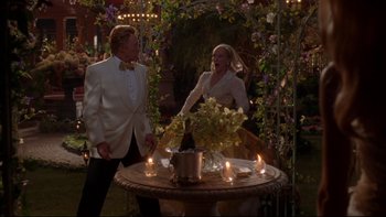 Movie still from “The Stepford Wives” (2004), directed by Frank Oz – A man and a woman standing in front of a round table; Wide shot, Over the shoulder angle