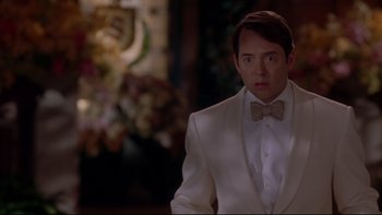 Movie still from “The Stepford Wives” (2004), directed by Frank Oz – A man wearing a white suit and bow tie; Medium shot, Over the shoulder angle