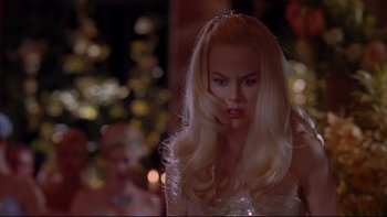 Movie still from “The Stepford Wives” (2004), directed by Frank Oz – A woman with long blonde hair wearing a tiara; Close Up shot, Over the shoulder angle