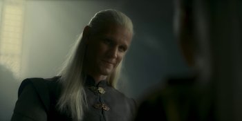 Movie still from “House of the Dragon” (2022), created by George R.R. Martin – A man with long white hair is looking at the camera; Close Up shot, Over the shoulder angle