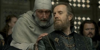 Movie still from “House of the Dragon” (2022), created by George R.R. Martin – A man with a beard is sitting next to a man with a beard; Close Up shot, Low angle