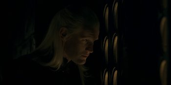 Movie still from “House of the Dragon” (2022), created by George R.R. Martin – A man with blonde hair looking into a window; Close Up shot, Over the shoulder angle