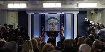 Movie still from “House of Cards” (2013), created by Beau Willimon – A woman standing at a podium in front of an audience; Wide shot, Low angle