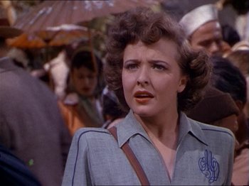 Movie still from “The Story of Dr. Wassell” (1944), directed by Cecil B. DeMille – A woman in a blue shirt is looking at the camera; Close Up shot, Over the shoulder angle
