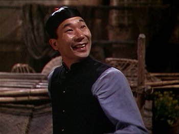 Movie still from “The Story of Dr. Wassell” (1944), directed by Cecil B. DeMille – A man smiling and wearing a black hat; Close Up shot, High angle
