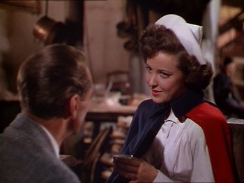 Movie still from “The Story of Dr. Wassell” (1944), directed by Cecil B. DeMille – A woman in a nurse's uniform talking to an older man; Medium shot, Over the shoulder angle