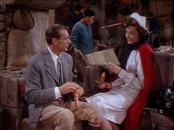 Movie still from “The Story of Dr. Wassell” (1944), directed by Cecil B. DeMille – A man and a woman sitting next to each other; Medium shot, Over the shoulder angle