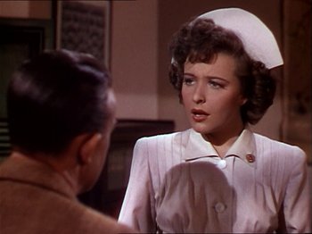 Movie still from “The Story of Dr. Wassell” (1944), directed by Cecil B. DeMille – A woman in a nurse's uniform talking to a man; Close Up shot, Over the shoulder angle