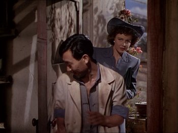 Movie still from “The Story of Dr. Wassell” (1944), directed by Cecil B. DeMille – A man and a woman standing next to each other in a doorway; Medium shot, Over the shoulder angle