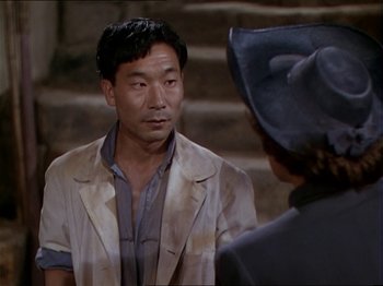 Movie still from “The Story of Dr. Wassell” (1944), directed by Cecil B. DeMille – A man and a woman talking to each other; Medium shot, High angle