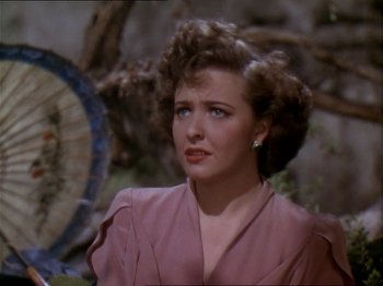 Movie still from “The Story of Dr. Wassell” (1944), directed by Cecil B. DeMille – A person wearing a pink dress; Close Up shot, High angle