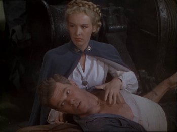 Movie still from “The Story of Dr. Wassell” (1944), directed by Cecil B. DeMille – A man and a woman are sitting on a bed; Medium shot, High angle