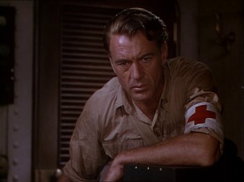 Movie still from “The Story of Dr. Wassell” (1944), directed by Cecil B. DeMille – A person wearing a shirt with a red cross on it; Close Up shot, Low angle
