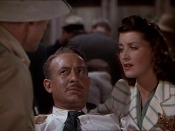 Movie still from “The Story of Dr. Wassell” (1944), directed by Cecil B. DeMille – A man and two women are talking to each other; Close Up shot, High angle