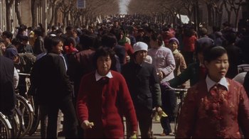 Movie still from “The Story of Qiu Ju” (1992), directed by Yimou Zhang – A crowd of people walking down a street; Wide shot, High angle