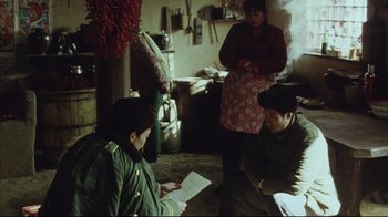 Movie still from “The Story of Qiu Ju” (1992), directed by Yimou Zhang – A group of people sitting in a living room; Medium shot, High angle