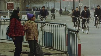 Movie still from “The Story of Qiu Ju” (1992), directed by Yimou Zhang – A young child standing next to a fence; Wide shot, High angle