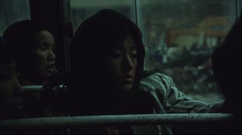 Movie still from “The Story of Qiu Ju” (1992), directed by Yimou Zhang – A person sitting on a bus in the dark; Close Up shot, Low angle